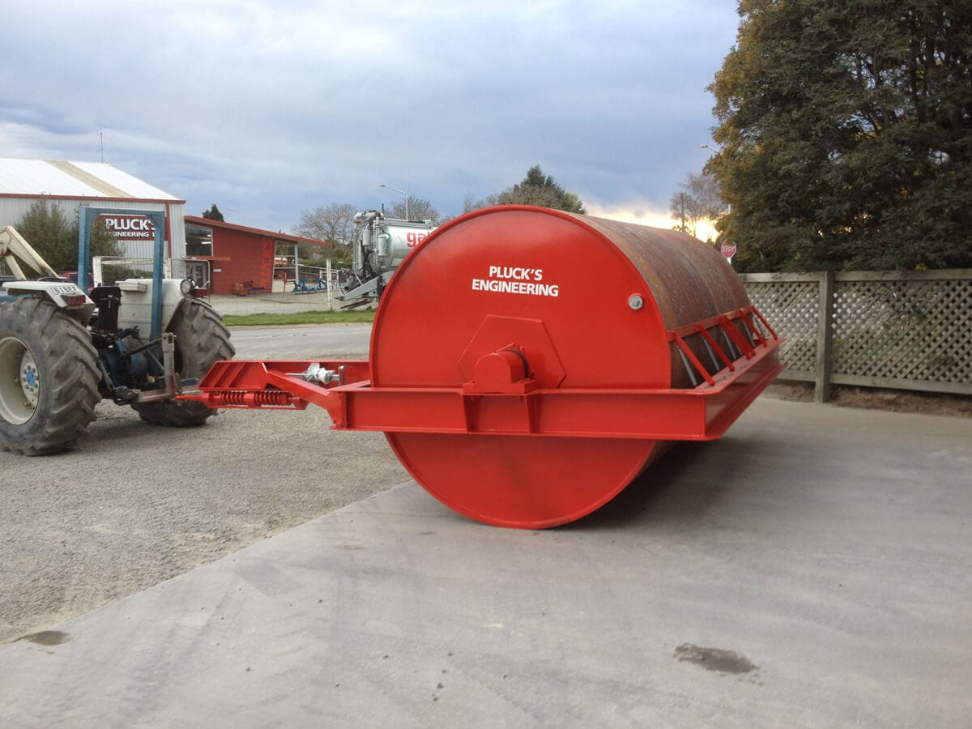 Plucks spring-loaded drawbar fitted to a heavy land roller, hitched to a tractor at Plucks Engineering in Rakaia