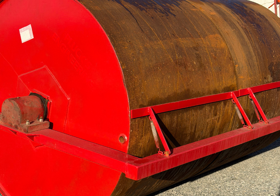Heavy-duty land roller with a durable, rust-resistant drum and red frame, designed for high-performance agricultural use. Built by Plucks Engineering for efficient field coverage.